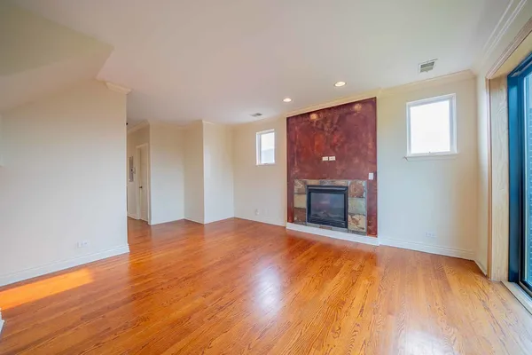 a view of an empty room with a fireplace and a window
