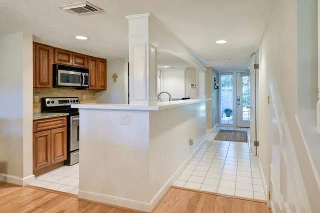 a kitchen with stainless steel appliances granite countertop a stove a sink and a microwave