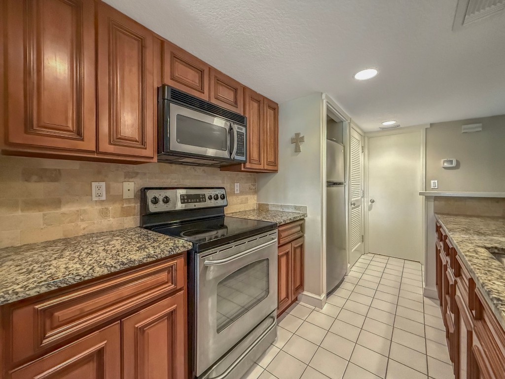 3052 Sea Marsh Road Fernandina Beach, FL 32034 - Photo 12 of 41 a kitchen with stainless steel appliances granite countertop a stove a sink and a microwave