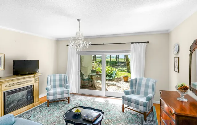 a living room with furniture a chandelier and a fireplace