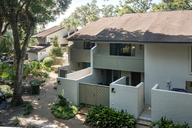 a view of a white house next to a yard
