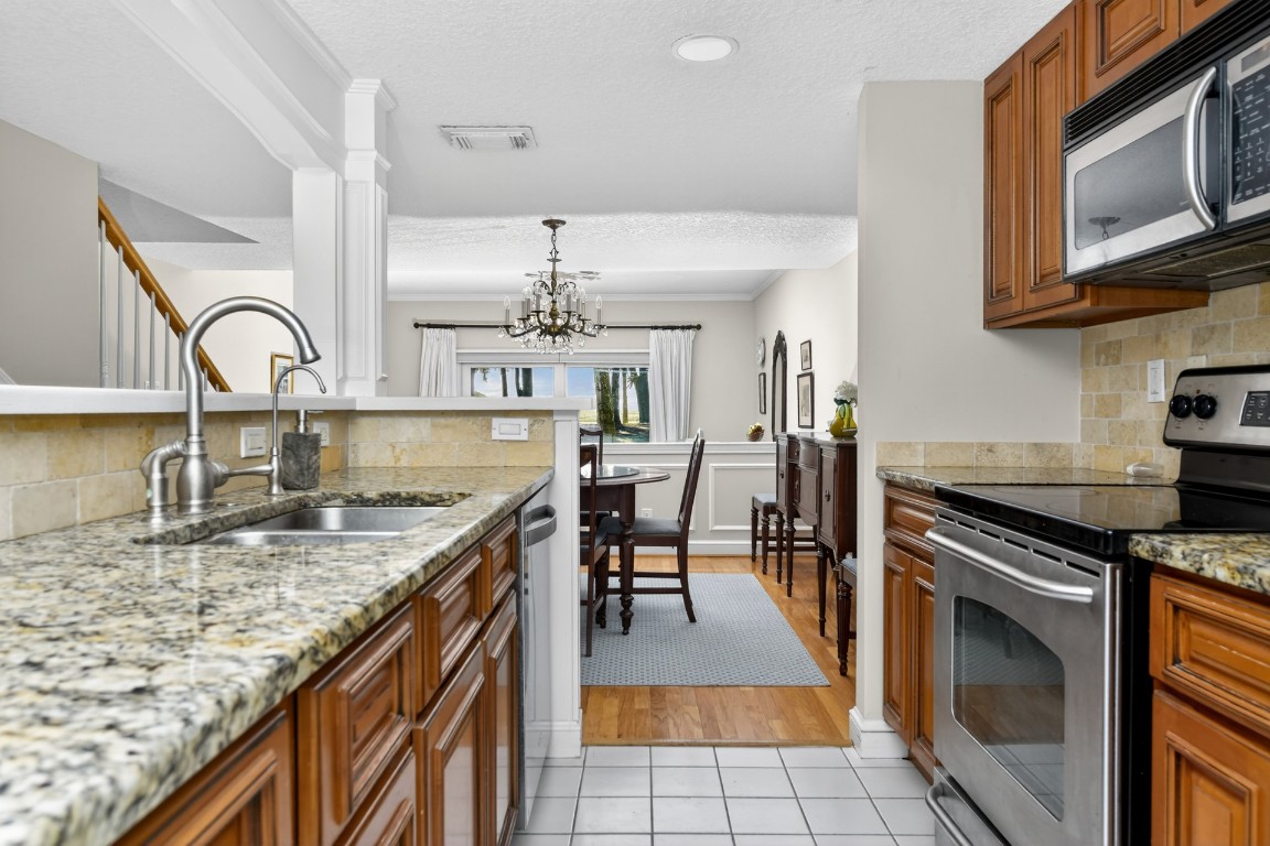 3052 Sea Marsh Road Fernandina Beach, FL 32034 - Photo 9 of 41 a kitchen with kitchen island granite countertop a stove top oven microwave and cabinets