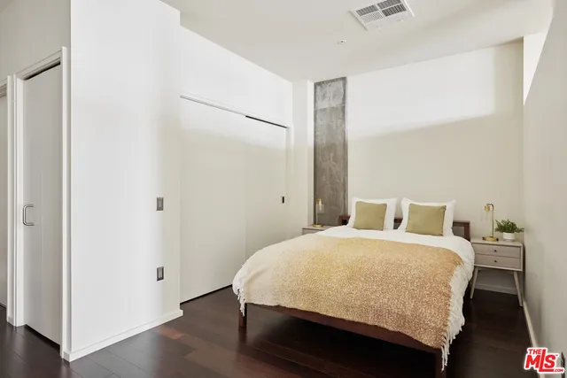 a bedroom with a bed and wooden floor