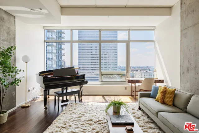 a living room with furniture and a potted plant next to a window
