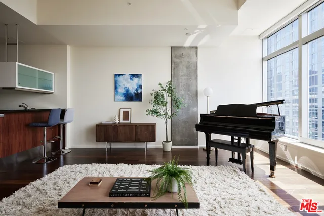 a living room with furniture a piano and a lamp