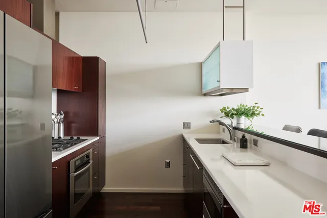 a kitchen with stainless steel appliances a sink a refrigerator and a counter top space