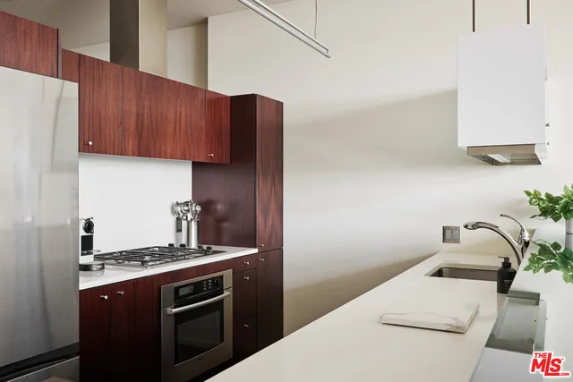 a kitchen with stainless steel appliances a sink a stove and white cabinets