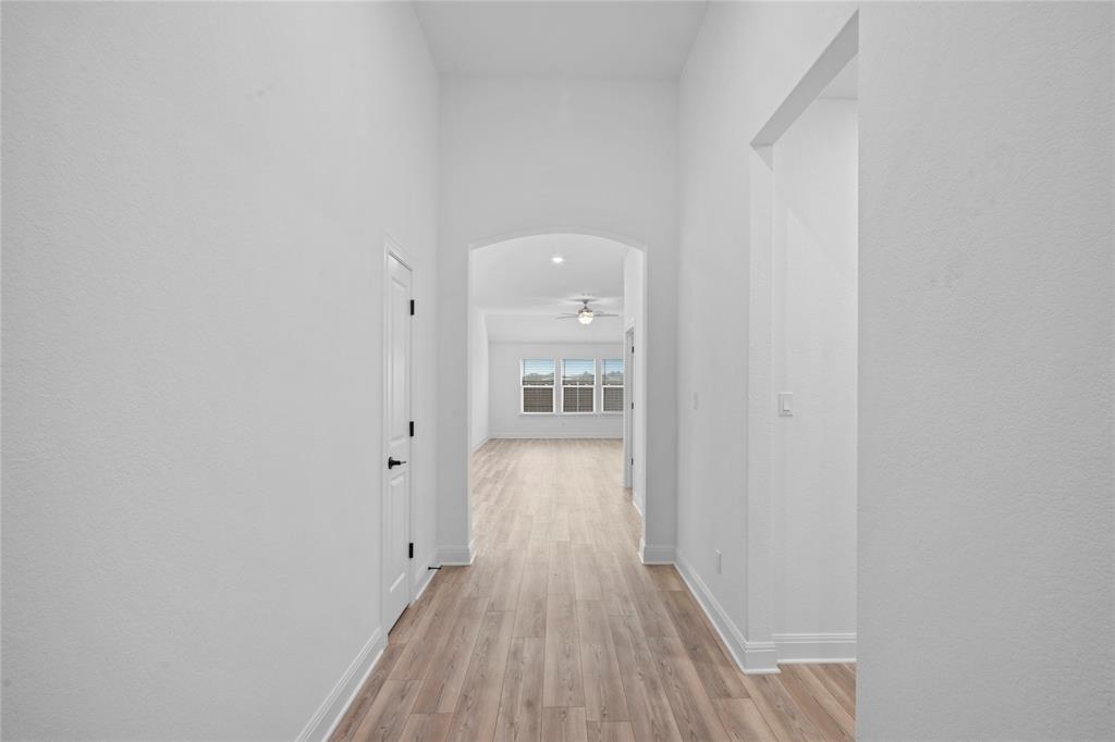 181 Slenderleaf Drive Marble Falls, TX 78654 - Photo 23 of 29 a view of a hallway with wooden floor and a bathroom