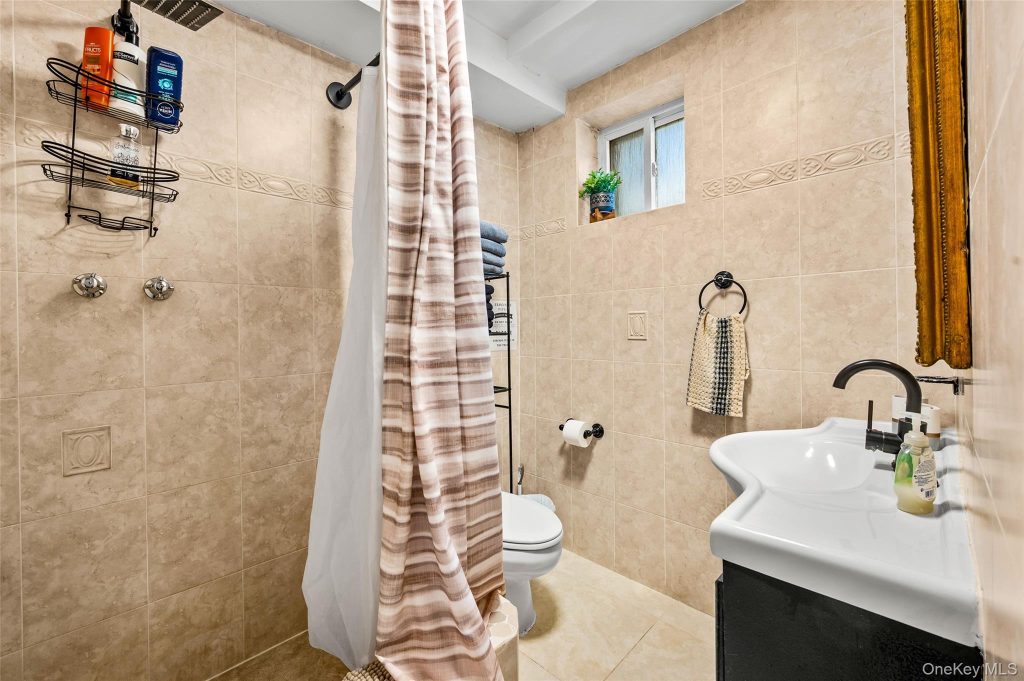 1016 Westwood Road Woodmere, NY 11598 - Photo 18 of 23 Bathroom with tile walls, tiled shower, vanity, and tile patterned flooring