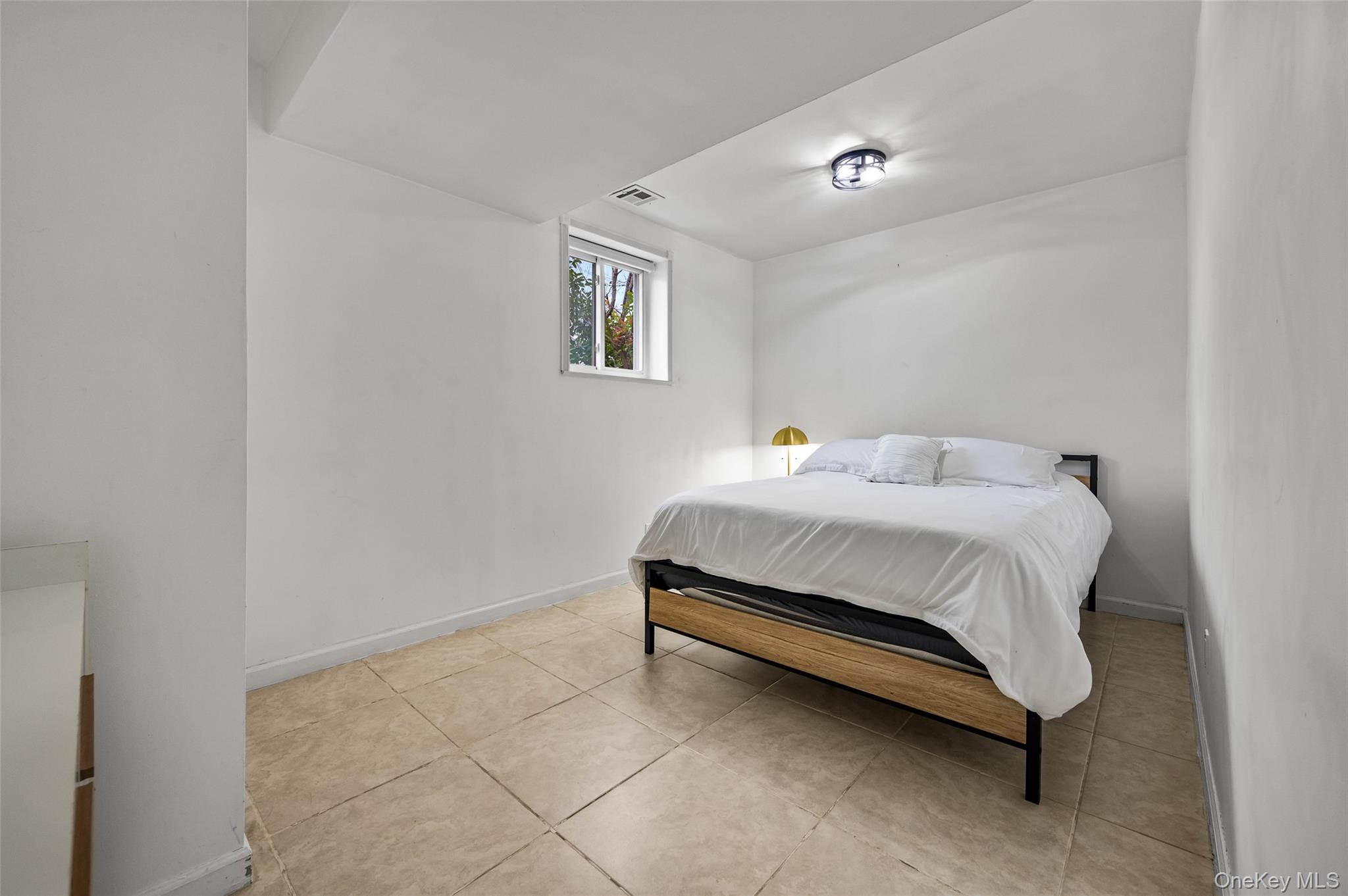 1016 Westwood Road Woodmere, NY 11598 - Photo 19 of 23 Bedroom with light tile patterned floors and baseboards