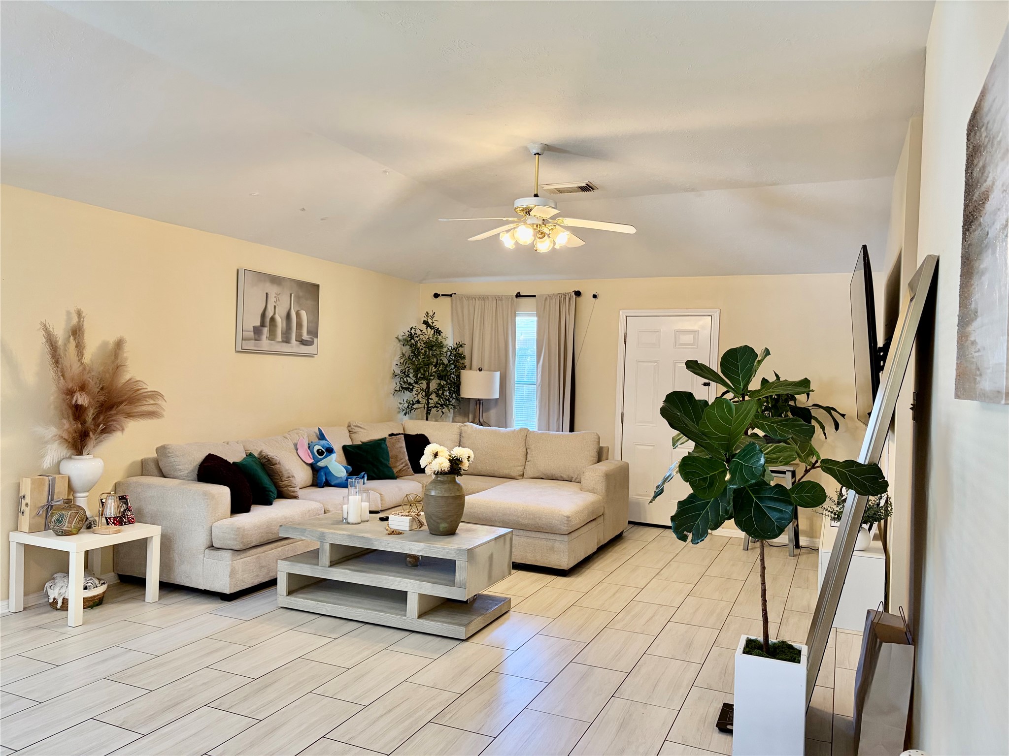 a living room with furniture flowerpot and a chandelier