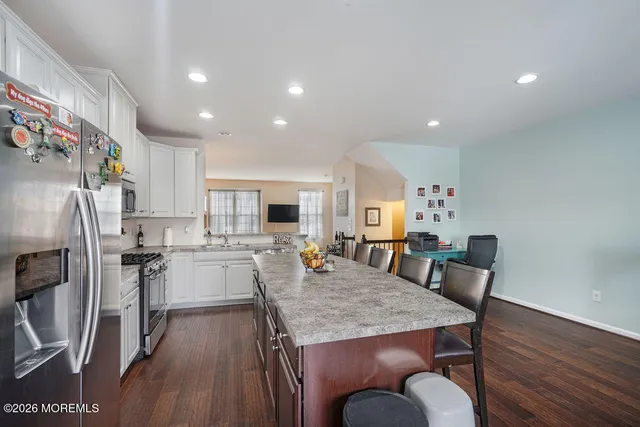 a kitchen with a table chairs and wooden floor