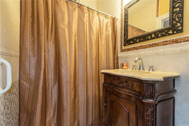 a utility room with a sink a mirror and a shower curtain