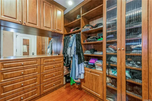 a view of walk in closet with clothes and shoes
