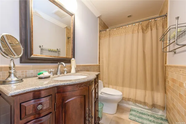 a bathroom with a granite countertop sink a toilet and a mirror