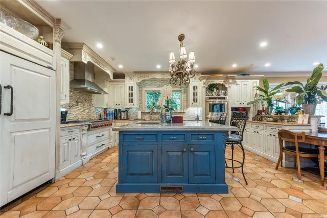 a kitchen with stainless steel appliances granite countertop wooden cabinets a dining table and chairs