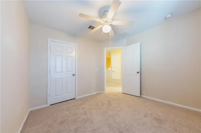 an empty room with a ceiling fan and a window