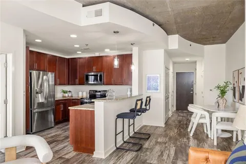 a kitchen with stainless steel appliances granite countertop a refrigerator and a stove top oven