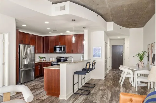 a kitchen with stainless steel appliances granite countertop a refrigerator and a stove top oven