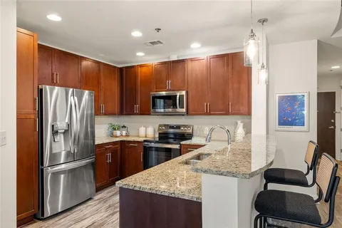 a kitchen with granite countertop kitchen island stainless steel appliances a refrigerator sink and microwave