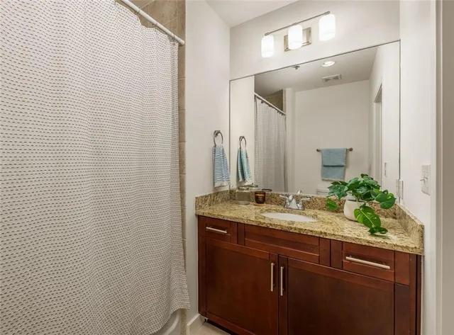 a bathroom with a granite countertop sink and a mirror