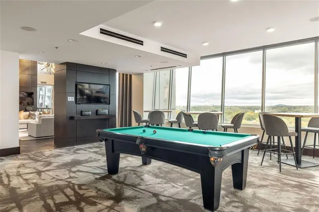 a room with pool table and windows
