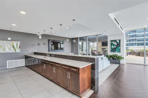 a large kitchen with stainless steel appliances a large counter top a stove and a wooden floors