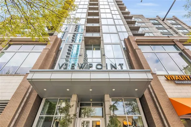 a front view of multi story building with retail shops