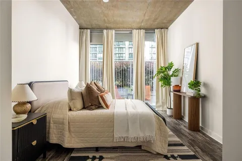 a bedroom with a large bed and a potted plant