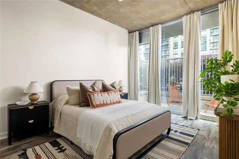 a bedroom with double bed and a potted plant