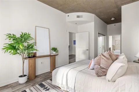 a bedroom with a bed and a potted plant