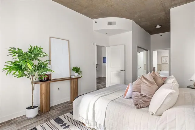 a bedroom with a bed and a potted plant