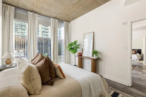 a bedroom with a bed and large windows