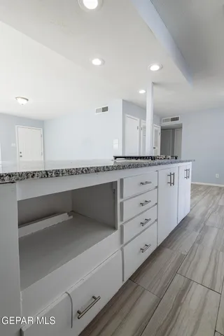 a spacious bathroom with a granite countertop sink and a large mirror