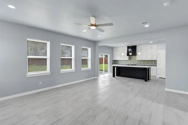 a view of an empty room with a window and fireplace