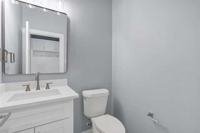 a bathroom with a toilet a sink and mirror