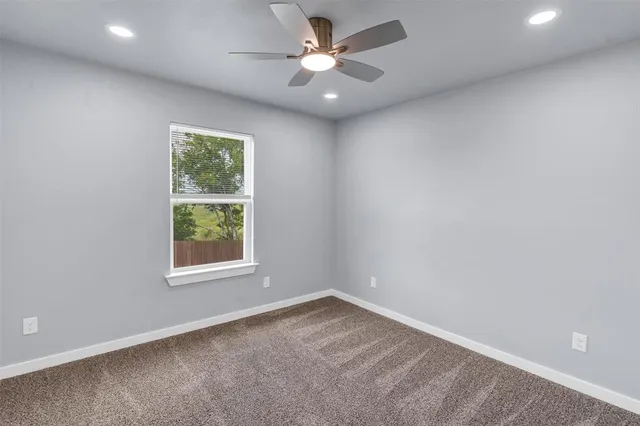 an empty room with closet and a chandelier fan