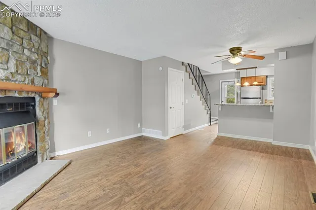 a view of a livingroom with wooden floor and a fireplace
