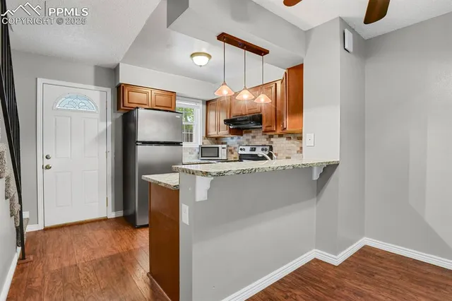 a kitchen with kitchen island a counter top space cabinets and stainless steel appliances
