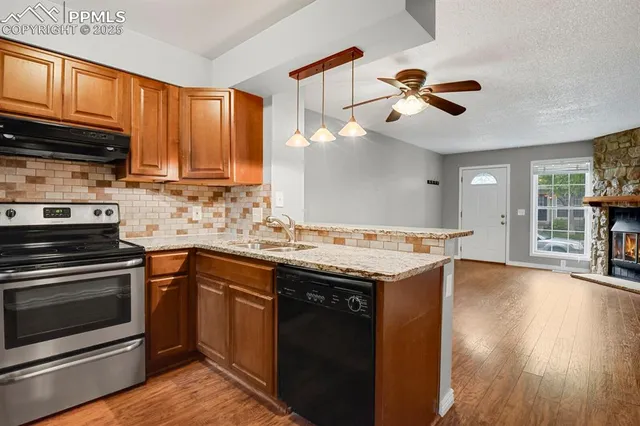 a kitchen with granite countertop a stove cabinets and wooden floor