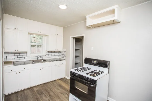 a kitchen with a stove and white cabinets