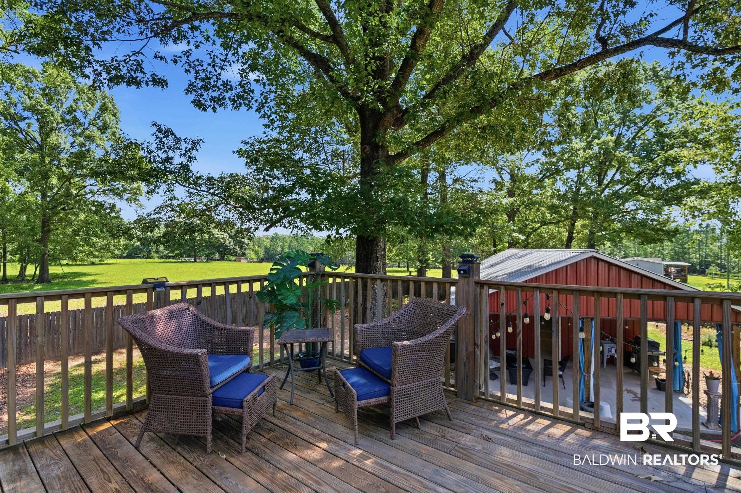 51620 Robert White Road Bay Minette, AL 36507 - Photo 64 of 81 Expansive wood deck with a full wood railing overlooking a red barn structure with a metal roof