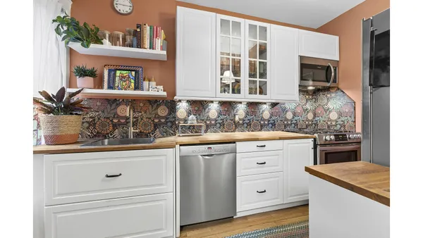 a kitchen with white cabinets and appliances