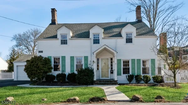 a front view of a house with a yard and potted plants