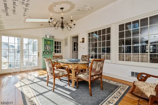 a dining room with furniture a chandelier and wooden floor