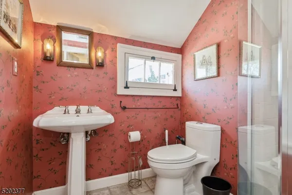 a bathroom with a sink a toilet and a mirror