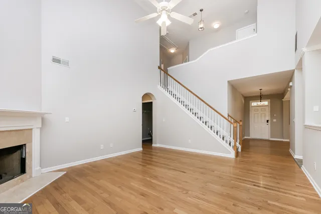 a view of an empty room with wooden floor a fireplace