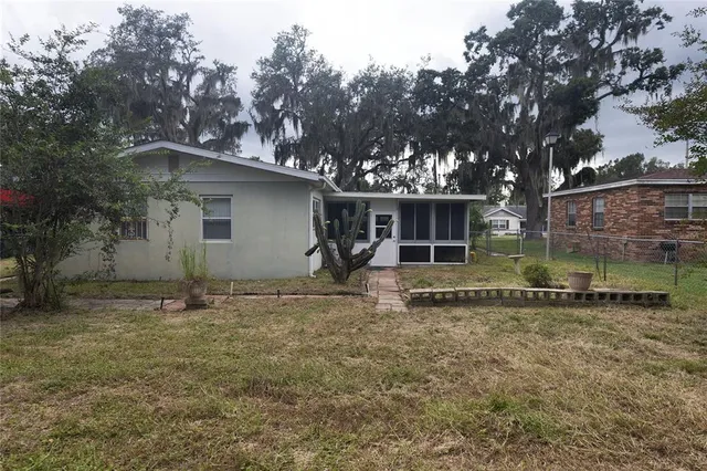 a view of a house with backyard and trees