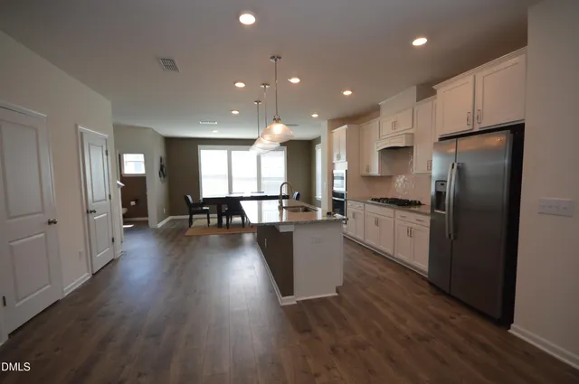 a large kitchen with stainless steel appliances a large counter top