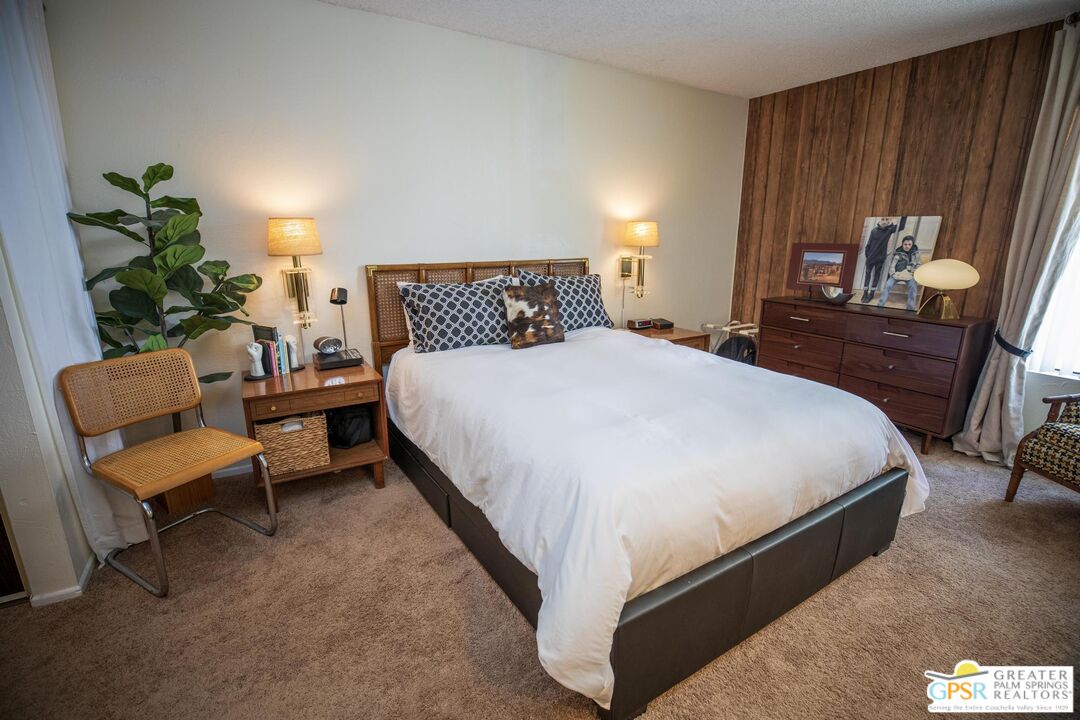 1050 Ramon Road, Unit 34 Palm Springs, CA 92264 - Photo 2 of 10 a bedroom with a bed and a chair